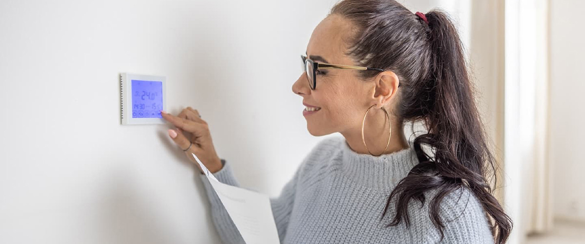 woman setting thermostat